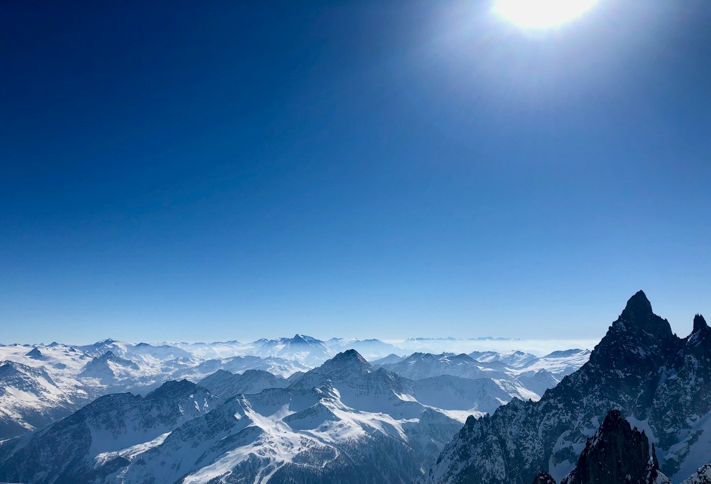 Schneebedeckte Berggipfel unter einem klaren blauen Himmel.