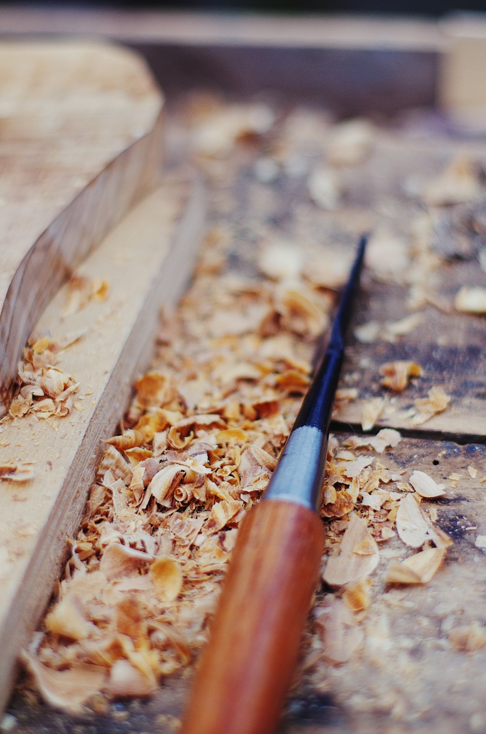 Holzschnitzbeitel auf einer Werkbank mit Spänen.